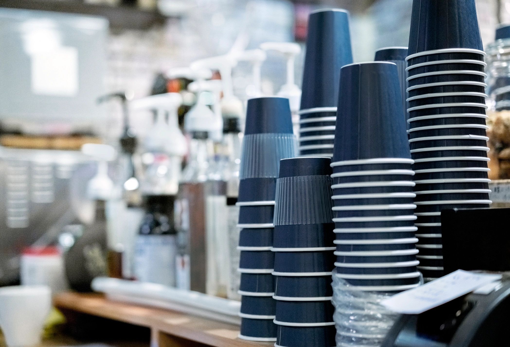 Stack of disposable cups on a coffee shop counter